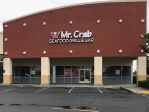 Image of large building with a crab and signage that reads "Mr. Crab Seafood & Grill."